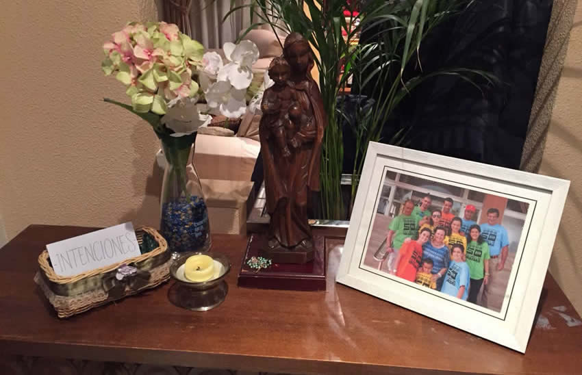 Imagen de la Virgen con foto de la familia y canasta de intenciones
